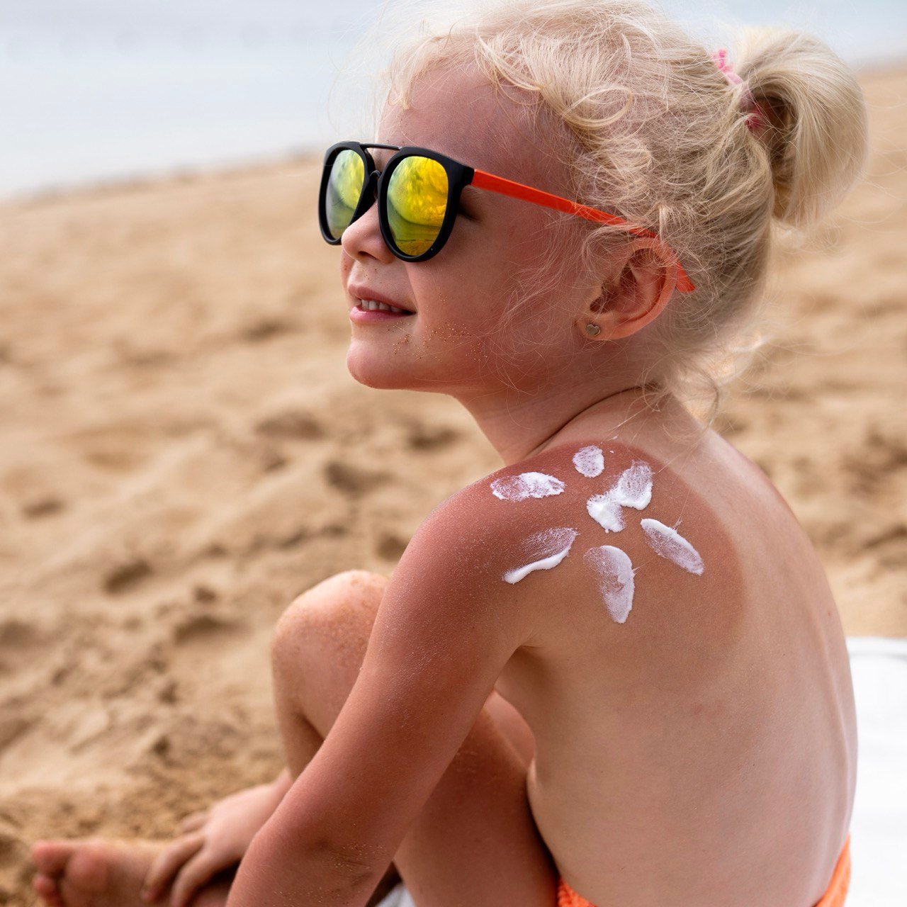 Baby met zonnehoedje in de schaduw, beschermd tegen een zonnesteek baby.