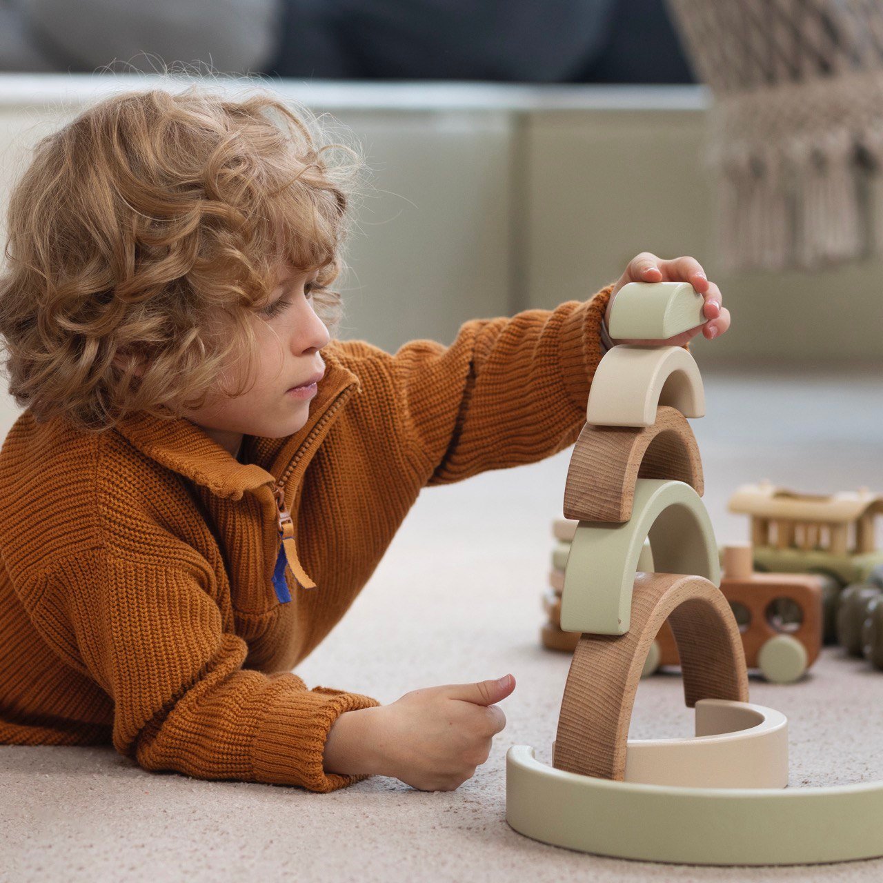 Vrolijk kind speelt met kleurrijke blokken, wat het belang van spel bij het cognitieve vaardigheden ontwikkelen illustreert.